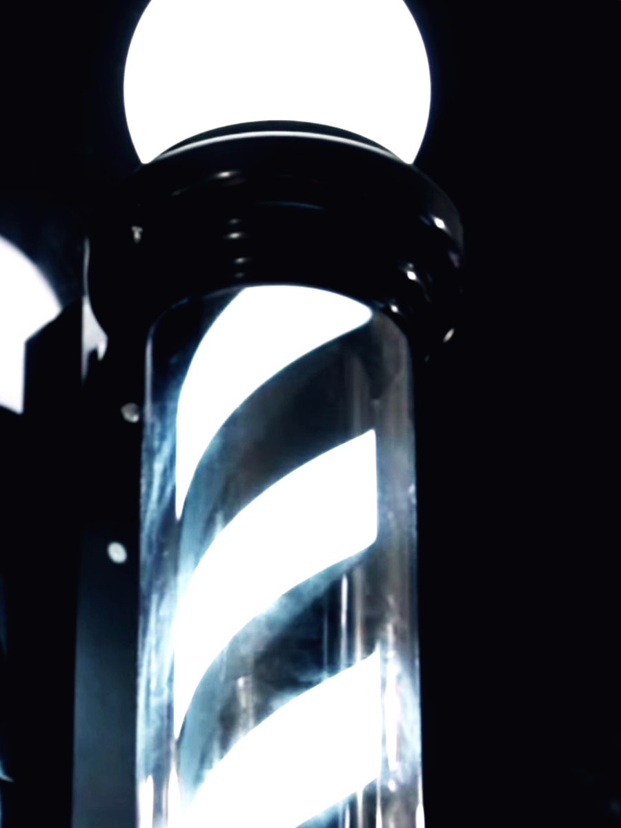 The barber pole lit up outside the shop