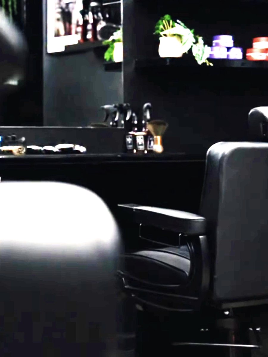 Inside the shop, black leather chairs and the product wall